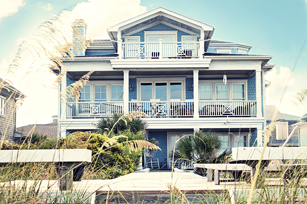 Seaside Park rentals can be as beautiful at this 3-story blue home with white trim surrounded by beach grass with a boardwalk leading to dunes