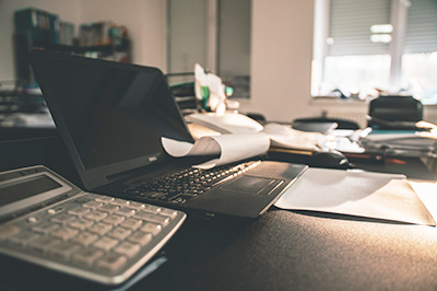 Seaside Park rentals; laptop, calculator and jumbled papers shown on desk