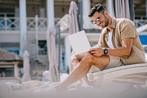 Man working on laptop outside Seaside Park rental