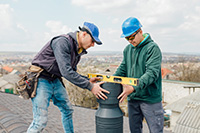 Belmar chimney service workers inspecting and repairing a chimney on the roof